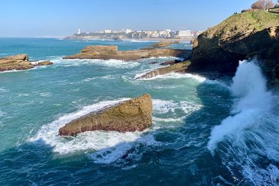 Scenic view of rocks in sea against sky