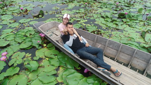 High angle portrait of couple sitting in boat on lake
