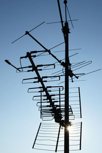 Low angle view of silhouette electricity pylon against sky