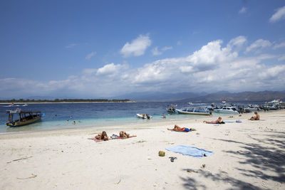 Panoramic view of people on beach against sky