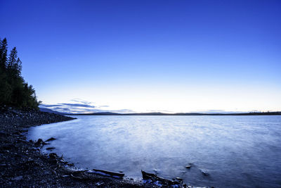 Scenic view of lake against clear blue sky