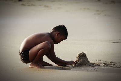 Side view of baby boy on beach