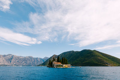 Scenic view of sea and mountains against sky