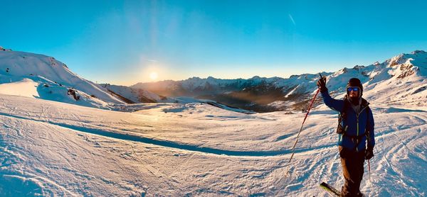 Man standing on snowcapped mountain against sky