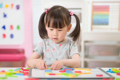 Young girl playing creative toy blocks for homeschooling