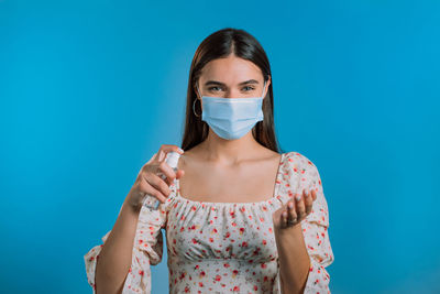 Portrait of beautiful young woman against blue background