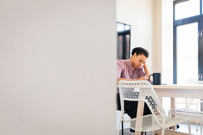 Young businesswoman writing at table in office