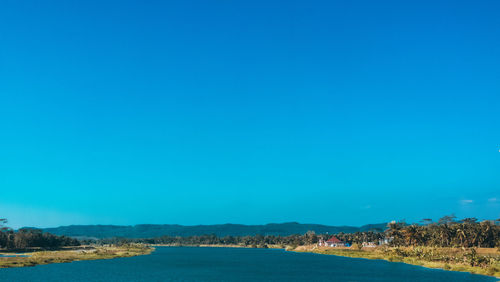 Scenic view of sea against clear blue sky