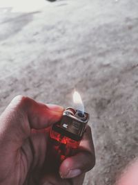 Close-up of hand holding lit candle