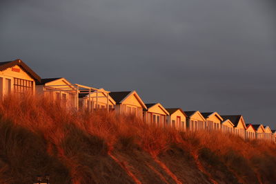 Low angle view of beachhouses against sky during sunset