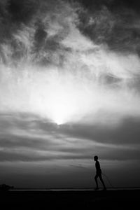 Silhouette man standing on land against sky