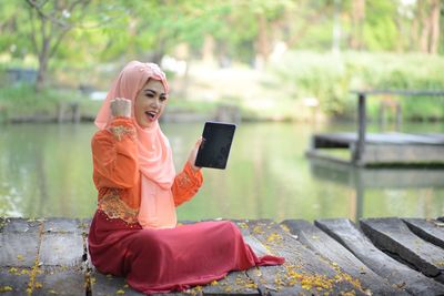 Young woman using mobile phone while sitting outdoors