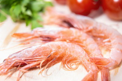 Close-up of shrimps by tomatoes on cutting board