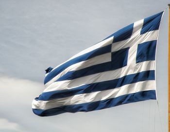 Low angle view of greek flag against sky