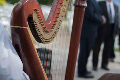 Cropped hand playing harp outdoors