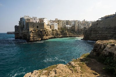 View of buildings by sea against sky