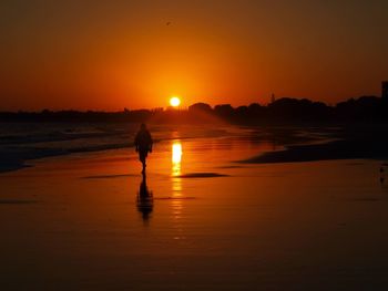 Silhouette man on beach during sunset