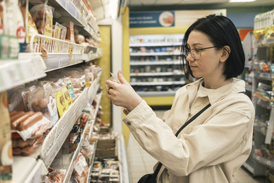 Side view of young woman standing in store
