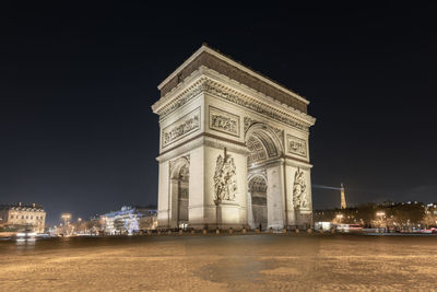 A night cityscape of paris with beautiful arc de triomphe arch triumph in center of frame with stars