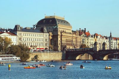 View of river by buildings in city against sky