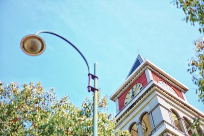 Low angle view of street light by building against sky