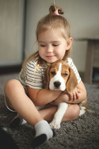 Portrait of cute girl with dog at home