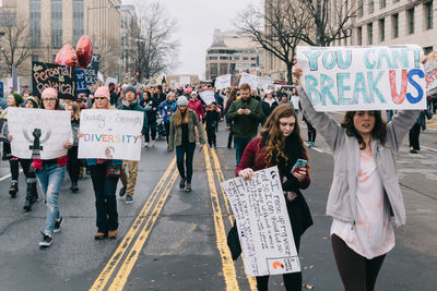 Group of people on road with city in background