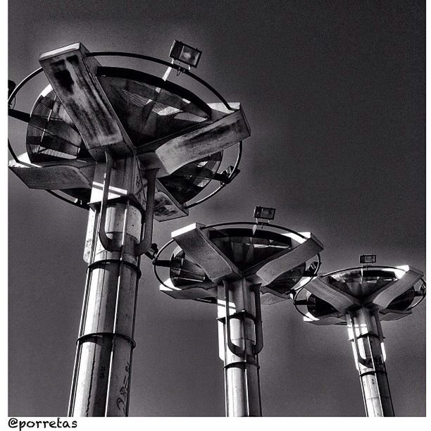 low angle view, built structure, architecture, building exterior, clear sky, sky, metal, street light, day, outdoors, no people, lighting equipment, auto post production filter, building, silhouette, copy space, metallic, technology, electricity, pole