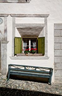Potted plants on bench against building