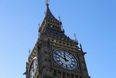 Low angle view of clock tower against blue sky