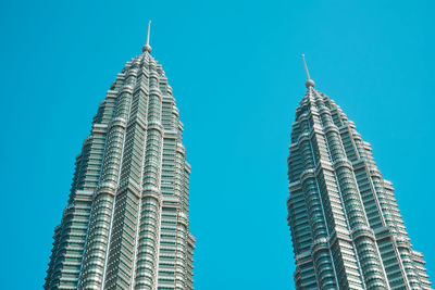 Low angle view of petronas towers against clear blue sky