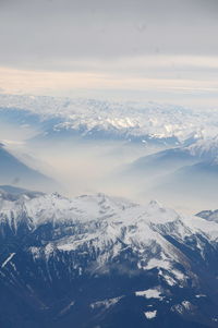Aerial view of snowcapped mountains against sky during winter