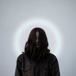 Portrait of beautiful young woman standing against rainbow over colored background