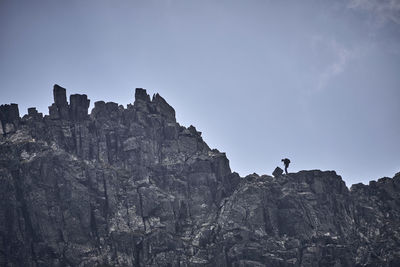 Low angle view of man on rock against sky