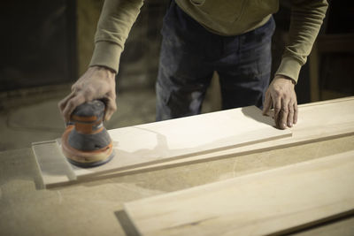 Midsection of man working on wood