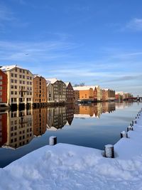 Reflection of buildings in trondheim city against sky