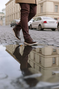 Low section of man walking on street