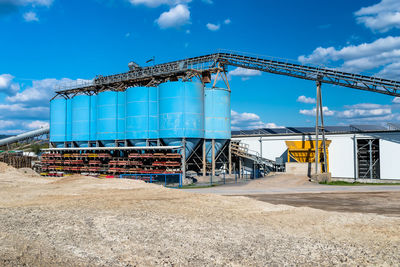 Big blue metallic industrial silos for the production of cement at an industrial cement plant