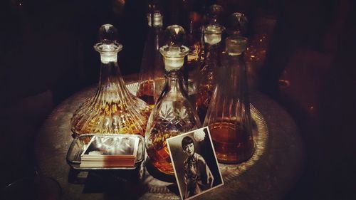 High angle view of drinks in bottles with female photograph on table