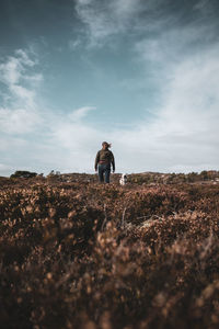 Surface level of woman with dog standing on land against sky