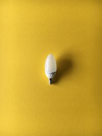 Directly above shot of light bulb on yellow background