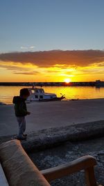 Man on beach against sky during sunset