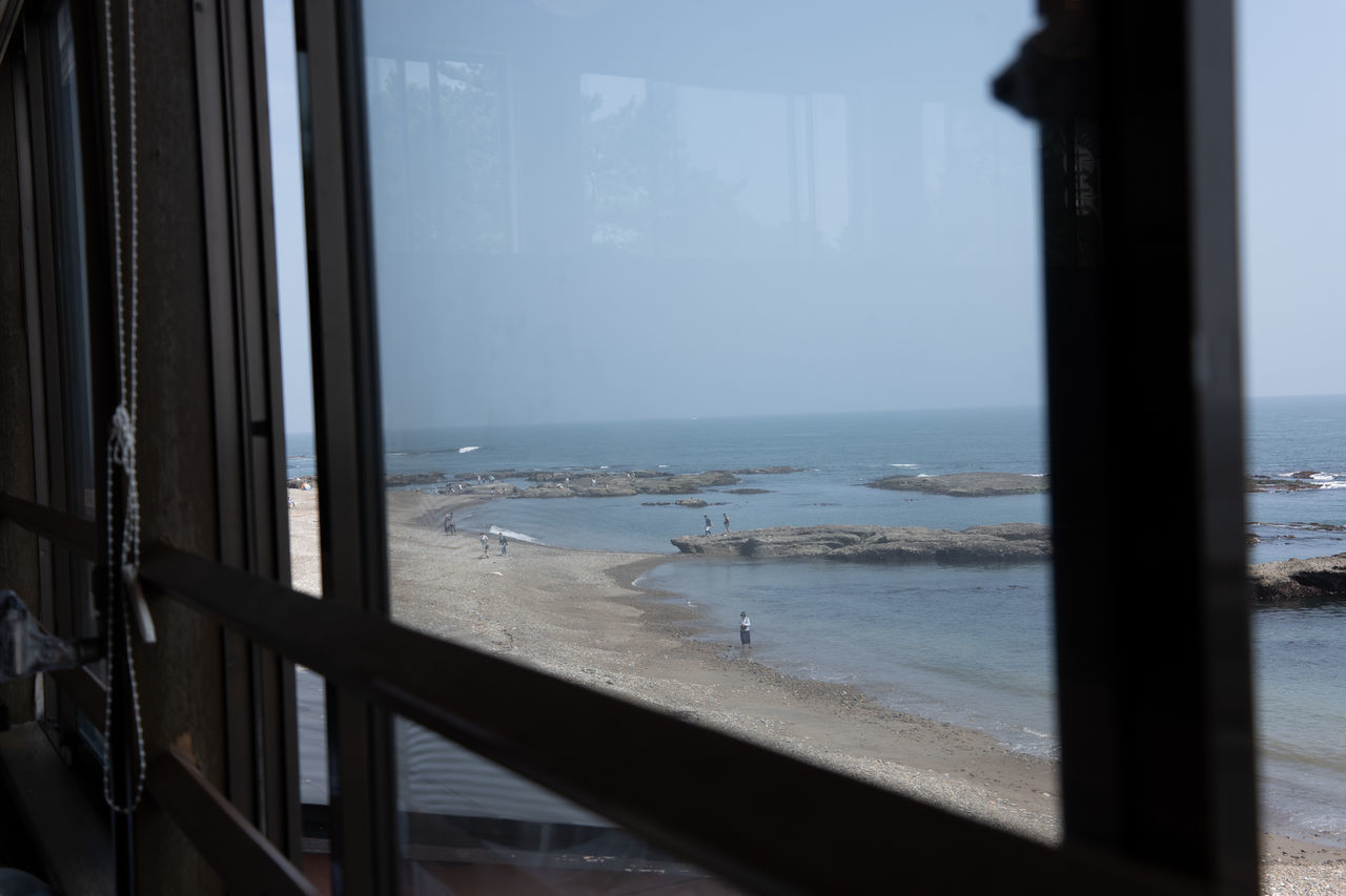 SCENIC VIEW OF SEA SEEN THROUGH GLASS WINDOW