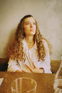 Portrait of young woman sitting on table