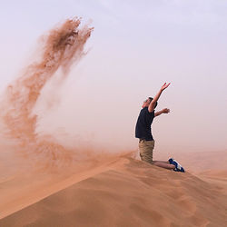 Full length of man walking on desert against sky