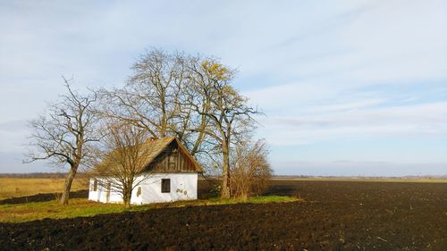 Abandoned house on field against sky