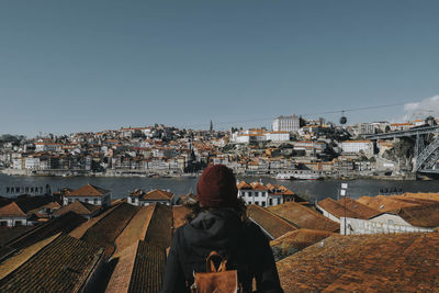 Rear view of man and buildings against clear sky