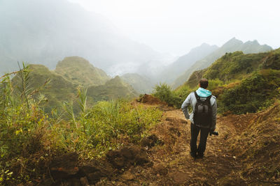 Man standing on land against mountains