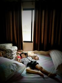 High angle view of boy sleeping on bed at home