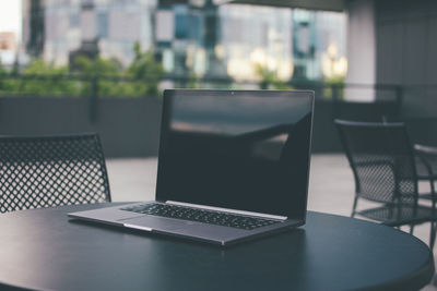 Close-up of laptop on table at cafe